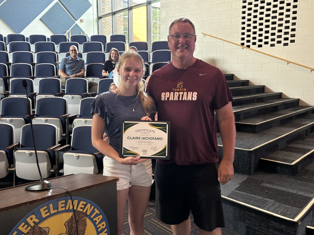 student poses with certificate